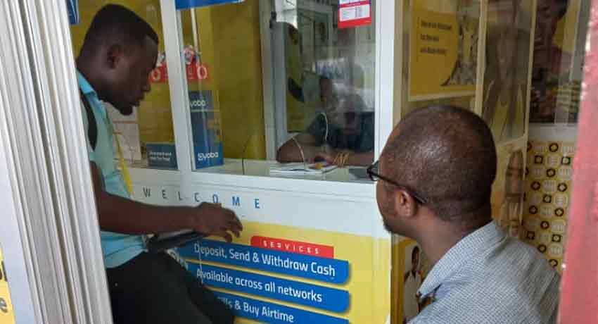 Enumerator interviewing a mobile money agent in Kumasi