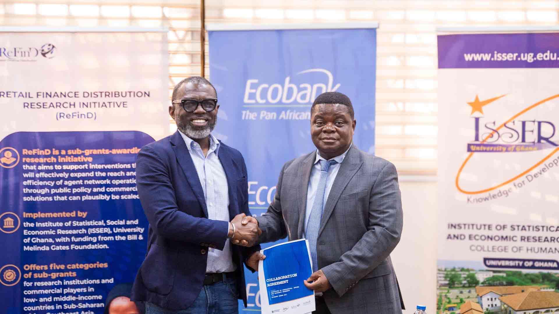 Mr. Tara Squire and Prof. Peter Quartey seal the partnership with a handshake after signing the landmark agreement to advance financial inclusion through research and innovation.